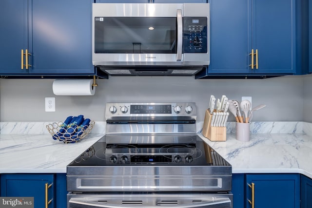 kitchen featuring light stone countertops, stainless steel appliances, and blue cabinets