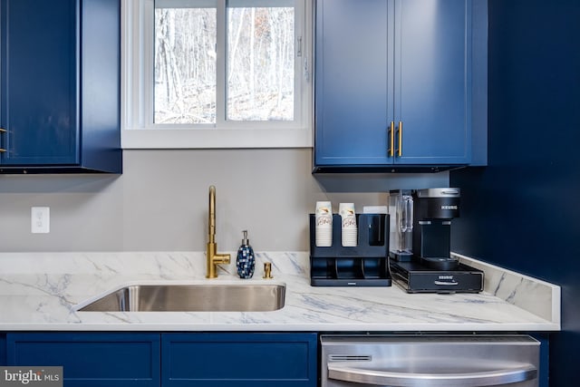 kitchen with light stone counters, sink, stainless steel dishwasher, and blue cabinets