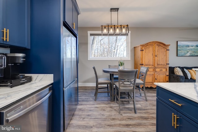 kitchen with pendant lighting, light wood-type flooring, blue cabinets, and appliances with stainless steel finishes