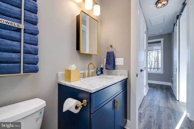 bathroom with vanity, toilet, and wood-type flooring