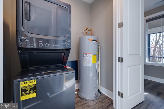 utilities featuring water heater and stacked washing maching and dryer