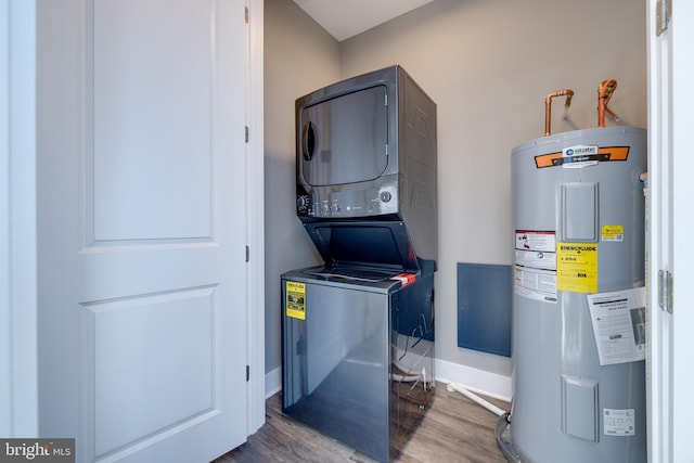 clothes washing area featuring hardwood / wood-style flooring, stacked washer / drying machine, and water heater