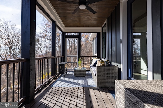 sunroom featuring ceiling fan and wooden ceiling