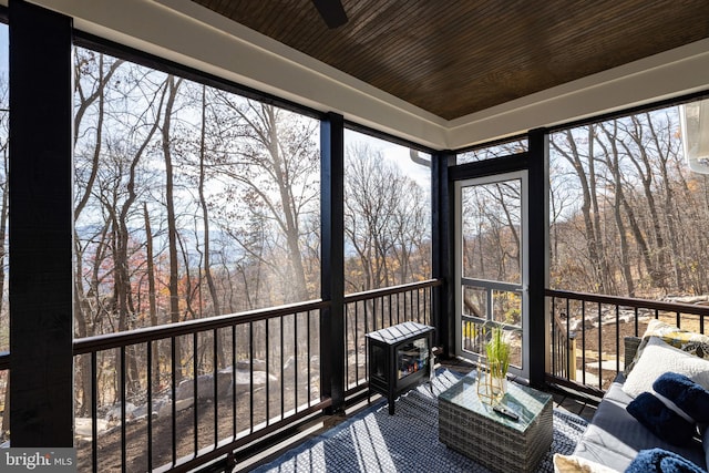 unfurnished sunroom with ceiling fan and wood ceiling