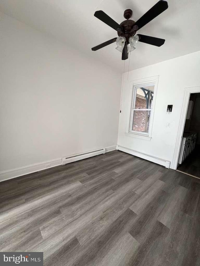 empty room with ceiling fan, dark hardwood / wood-style floors, and a baseboard heating unit