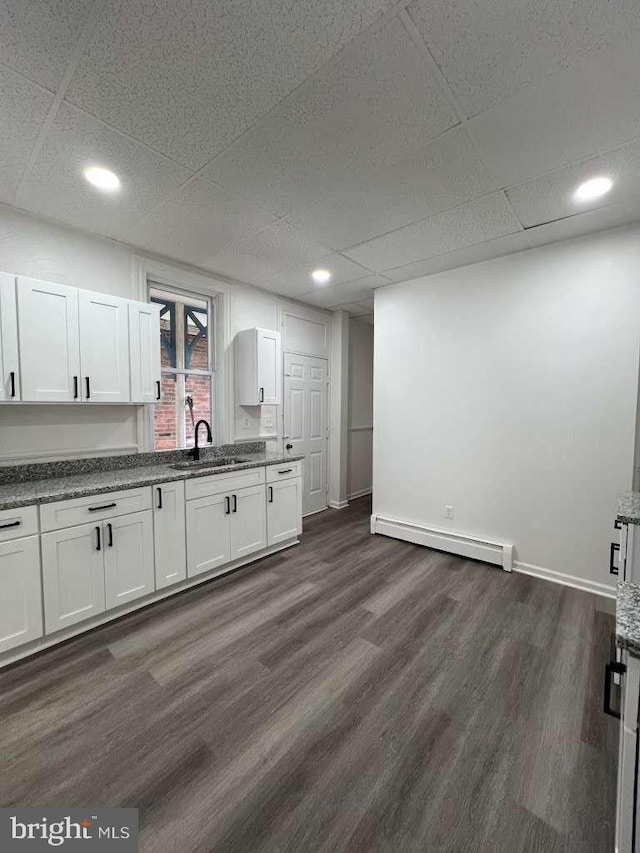 kitchen with dark hardwood / wood-style flooring, sink, white cabinets, and a baseboard radiator