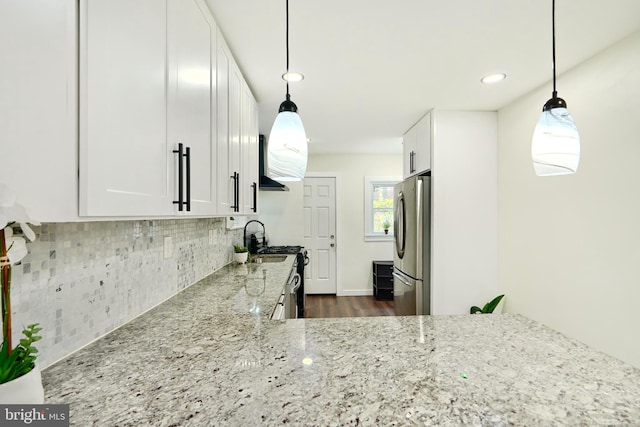 kitchen with white cabinets, light stone counters, decorative light fixtures, dark hardwood / wood-style flooring, and stainless steel appliances