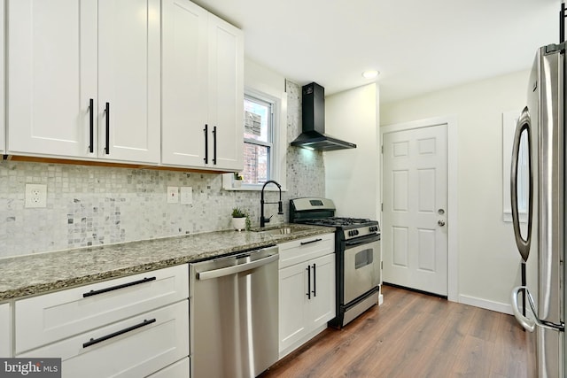 kitchen featuring white cabinetry, sink, wall chimney exhaust hood, stainless steel appliances, and dark hardwood / wood-style floors