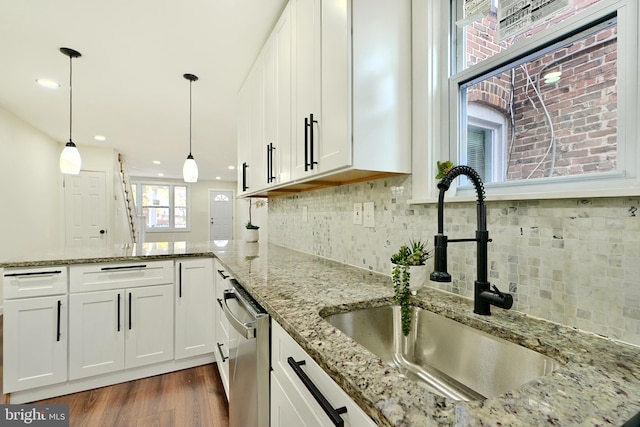 kitchen with stainless steel dishwasher, white cabinets, and sink