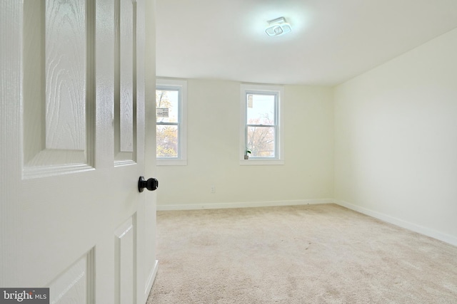 unfurnished room with light carpet