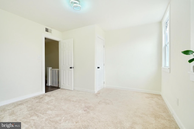 carpeted empty room featuring a wealth of natural light