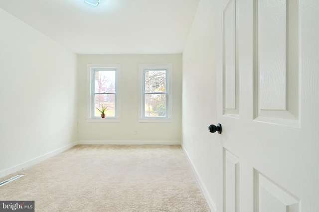 spare room featuring light carpet