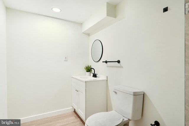 bathroom with vanity, toilet, and wood-type flooring