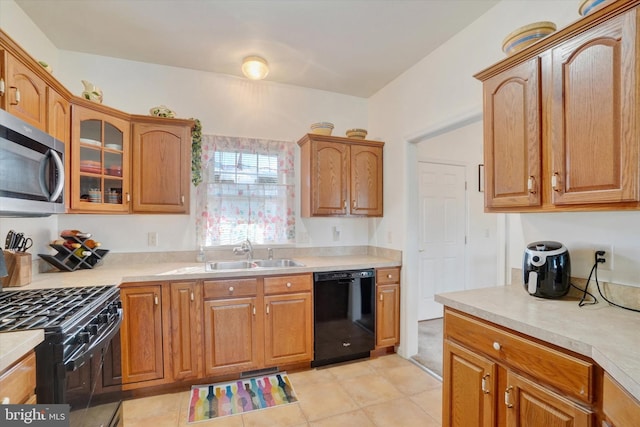 kitchen with light tile patterned floors, sink, and black appliances