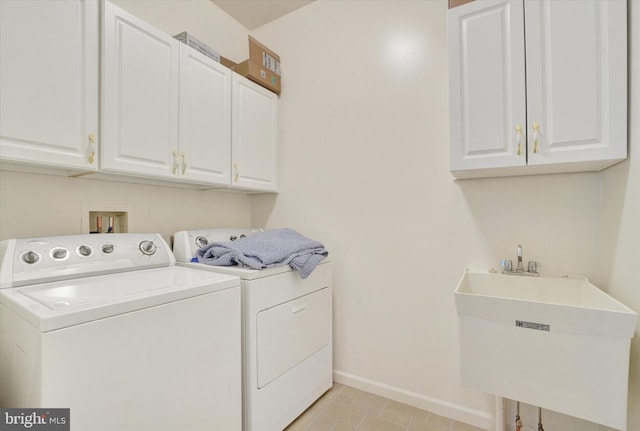 laundry room with cabinets, independent washer and dryer, light tile patterned floors, and sink