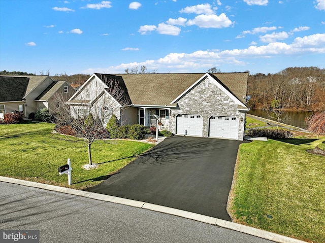 view of front of house with a garage, a water view, and a front yard