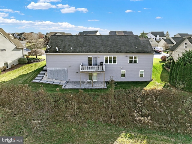 back of house with a yard, a balcony, and a patio