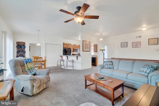 carpeted living room featuring ceiling fan