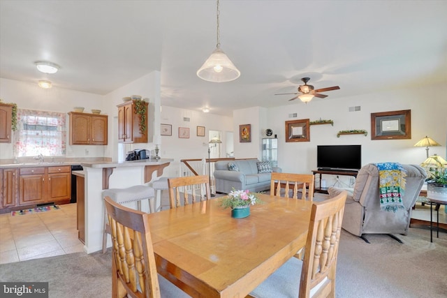 dining area with light carpet, ceiling fan, and sink