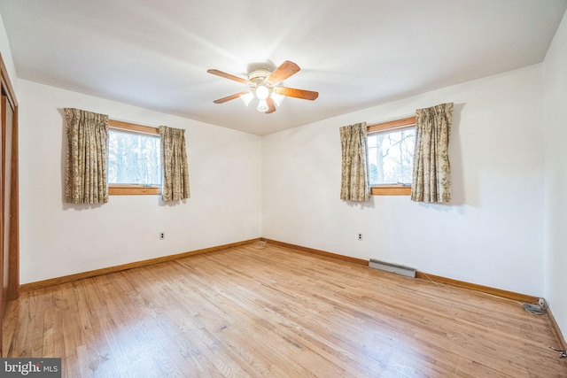 empty room with light hardwood / wood-style flooring, a wealth of natural light, and ceiling fan