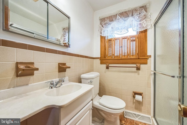 bathroom featuring vanity, tile walls, and toilet