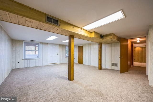 basement featuring carpet floors and wood walls