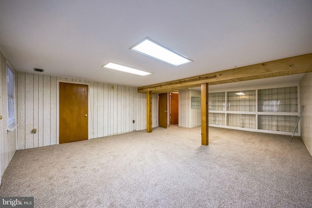 basement with carpet flooring and wood walls