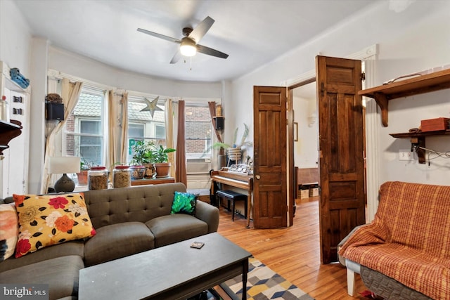 living room featuring ceiling fan, cooling unit, and light wood-type flooring