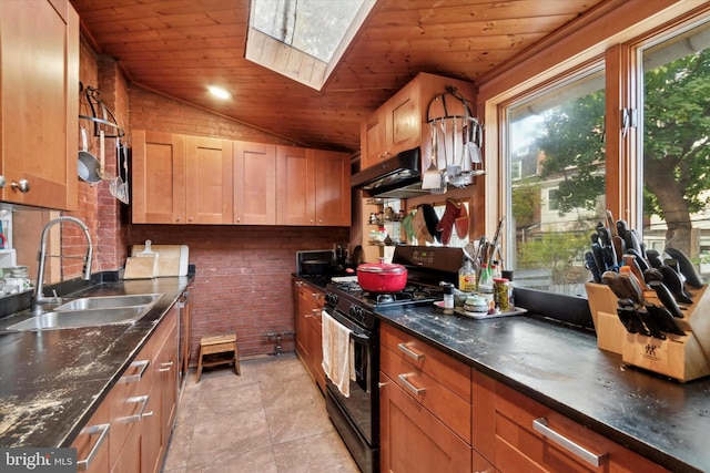 kitchen featuring wooden ceiling, black range with gas stovetop, sink, vaulted ceiling with skylight, and brick wall