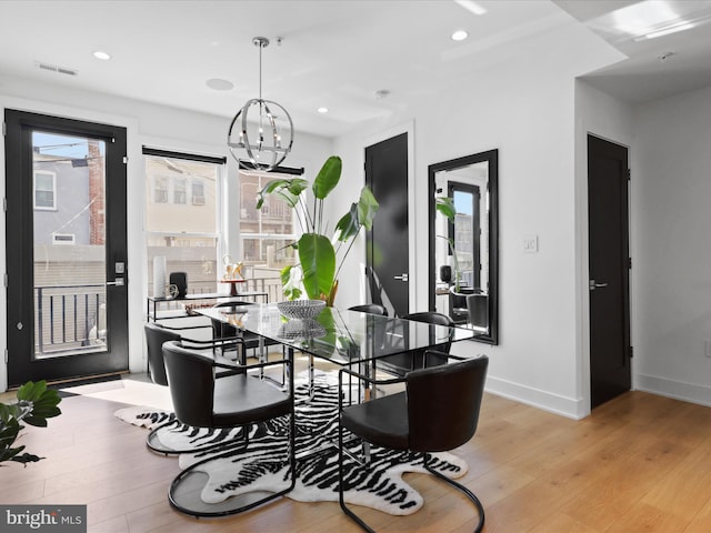 dining room with light hardwood / wood-style floors and an inviting chandelier