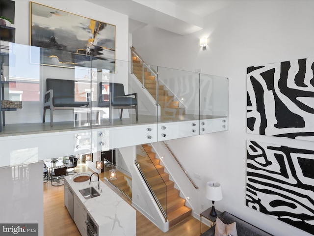 stairs featuring sink and hardwood / wood-style flooring