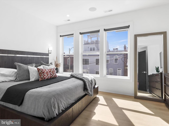 bedroom with light hardwood / wood-style flooring and multiple windows