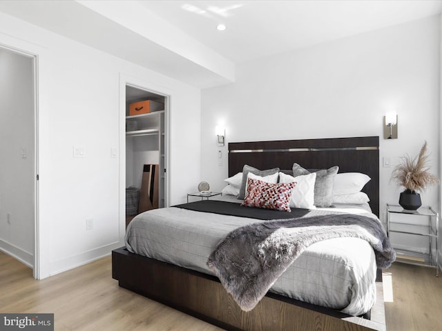 bedroom with light hardwood / wood-style floors, a spacious closet, and a closet