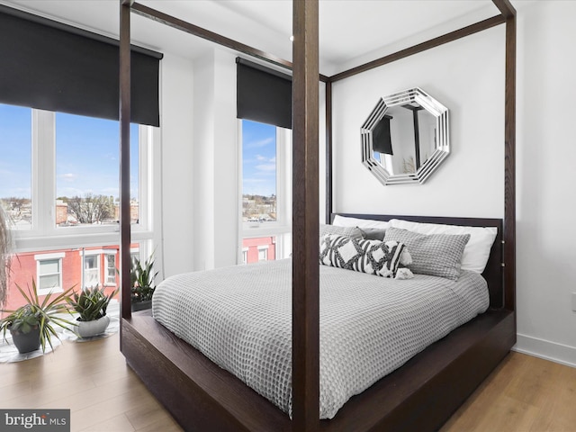 bedroom with multiple windows and light wood-type flooring