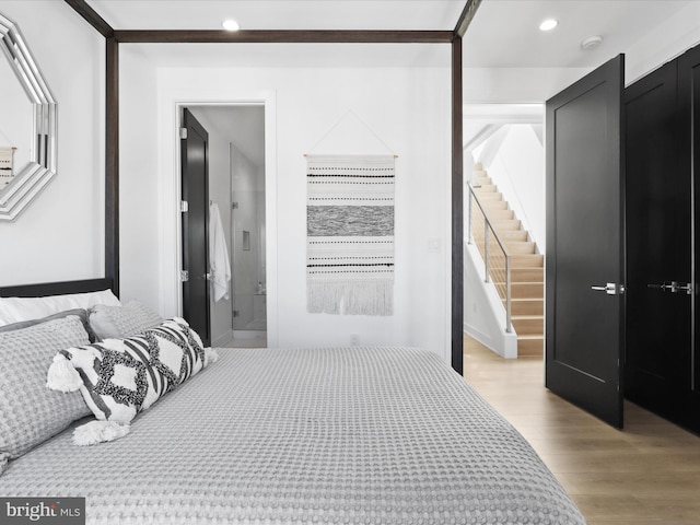 bedroom featuring ensuite bathroom and light hardwood / wood-style floors