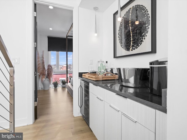 bar featuring white cabinetry, hanging light fixtures, a wall of windows, wine cooler, and light wood-type flooring