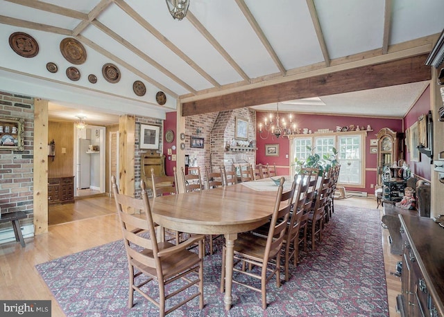 dining area with vaulted ceiling with beams, light wood-type flooring, brick wall, and an inviting chandelier