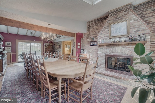 dining area featuring a brick fireplace, vaulted ceiling with beams, a textured ceiling, a notable chandelier, and wood-type flooring