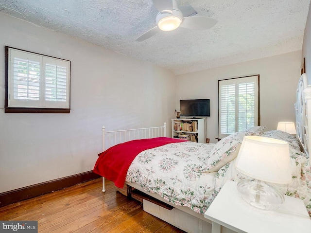 bedroom featuring hardwood / wood-style flooring, ceiling fan, and a textured ceiling