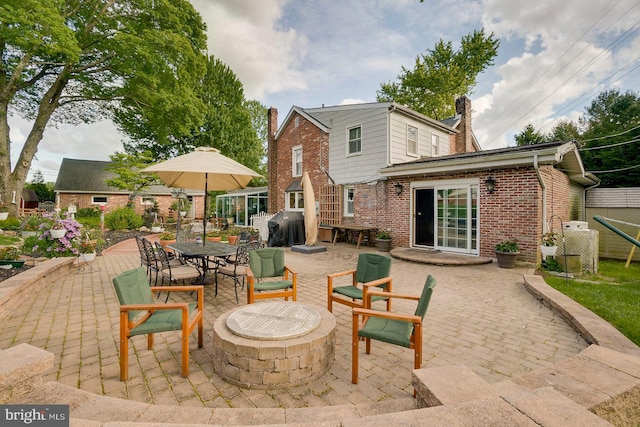 view of patio with area for grilling and an outdoor fire pit