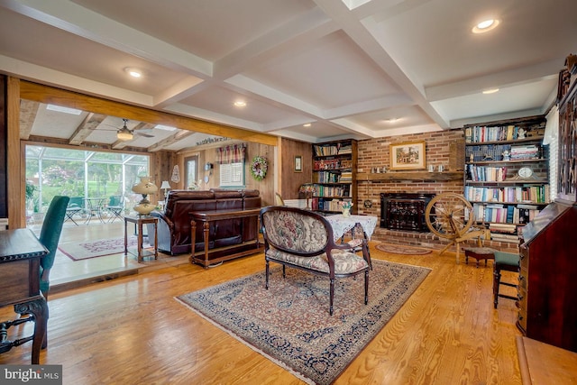 living room with ceiling fan, beam ceiling, light wood-type flooring, and coffered ceiling