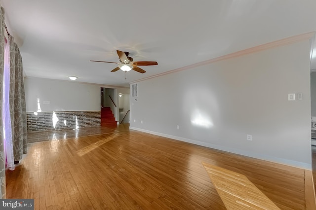 empty room featuring wood-type flooring, ceiling fan, and crown molding