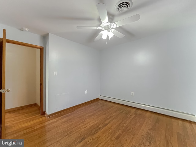 spare room with light wood-type flooring, baseboard heating, and ceiling fan