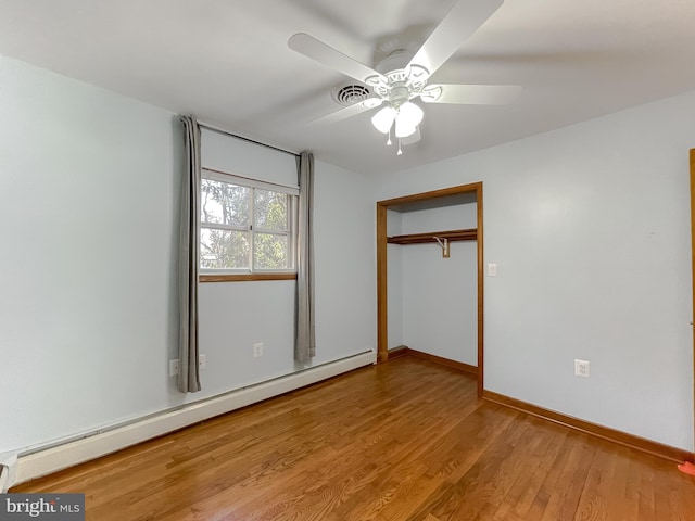 unfurnished bedroom featuring baseboard heating, a closet, ceiling fan, and light hardwood / wood-style flooring