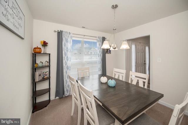 dining room with carpet floors and a notable chandelier