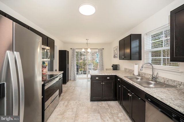 kitchen with a wealth of natural light, hanging light fixtures, sink, and appliances with stainless steel finishes