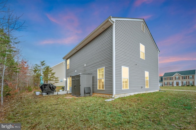 back house at dusk with a yard