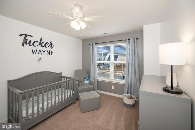 bedroom with carpet flooring, ceiling fan, and a nursery area