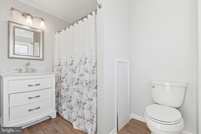 bathroom featuring hardwood / wood-style flooring, vanity, toilet, and a shower with shower curtain