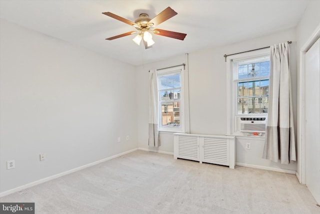 carpeted spare room featuring ceiling fan and plenty of natural light